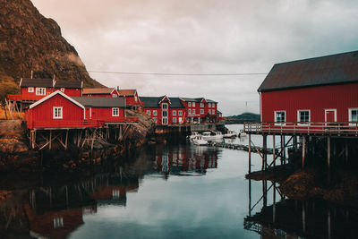 Buildings by lake against sky in city in norway