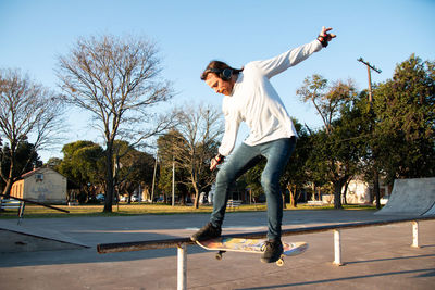 Skateboarder doing a trick wearing headphones