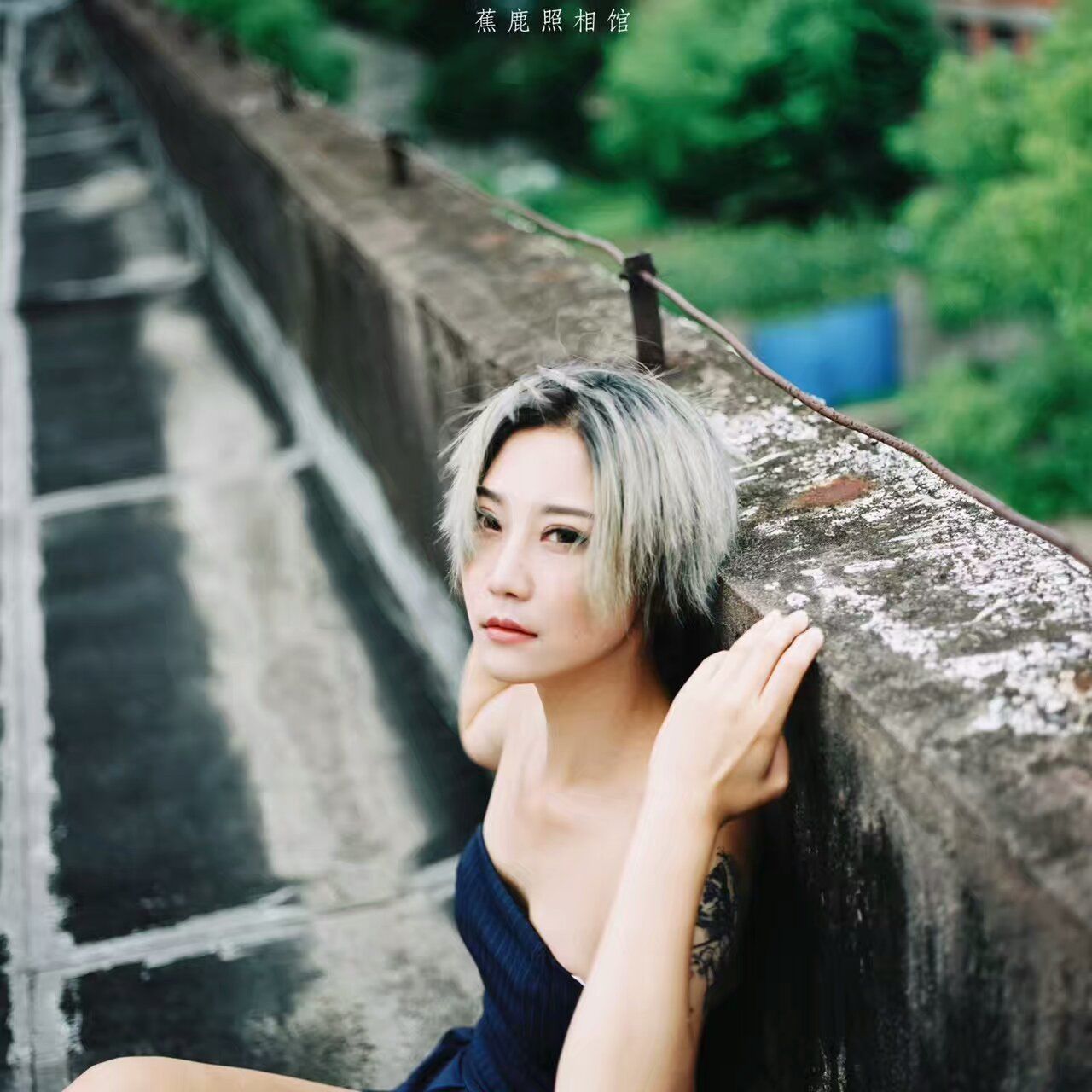 PORTRAIT OF YOUNG WOMAN STANDING AGAINST WALL