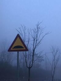 Road sign against sky during winter