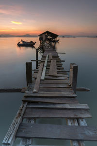 Pier over sea against sky during sunset