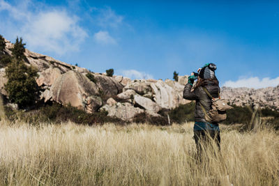 Full length of man climbing on field against sky