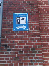 Low angle view of sign on brick wall