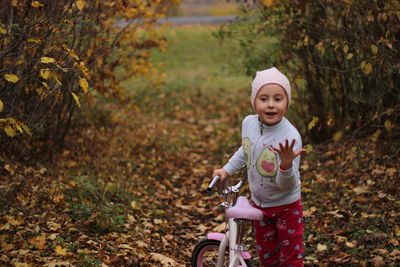 Portrait of a cute girl riding bicycle on field