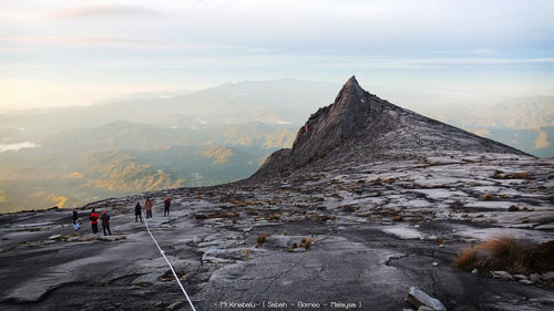 People on mountain against sky