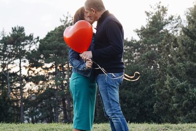 Rear view of man holding balloons