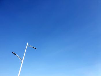 Low angle view of bird flying against clear blue sky