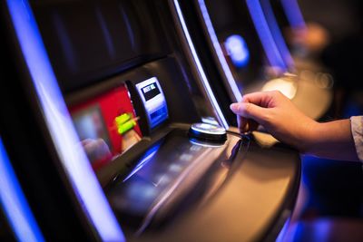 Close-up of hand playing on slot machine