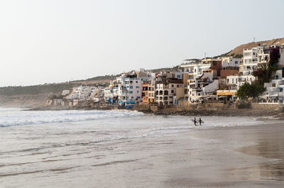 Town by sea against clear sky