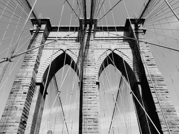 Low angle view of suspension bridge against sky - brooklyn bridge