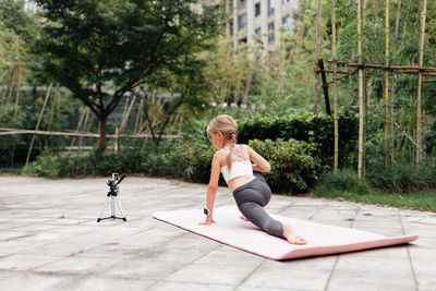 Full length of young woman exercising in gym