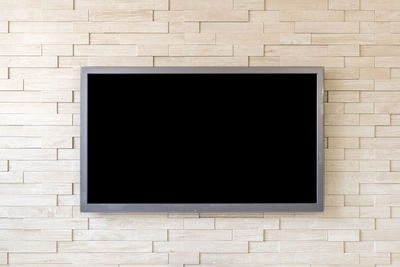 Blank television screen on wall at home