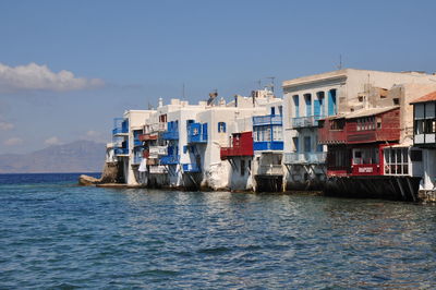 Houses by sea against sky