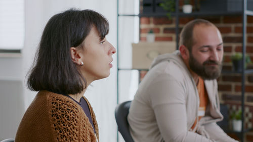 Side view of young couple standing in office