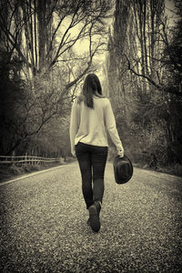 Rear view of woman walking on road