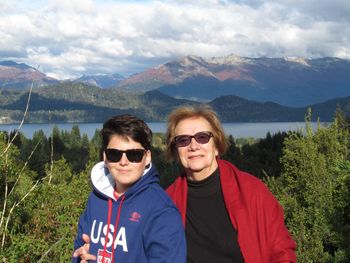 Portrait of mother and son standing at lakeshore against mountains