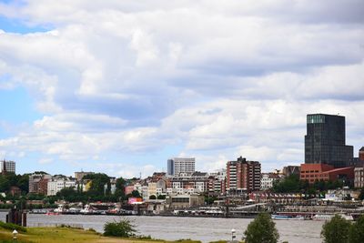 River by buildings in city against sky