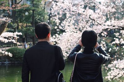 Rear view of woman standing by tree