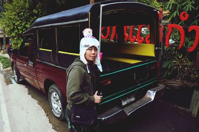 Portrait of man standing by car