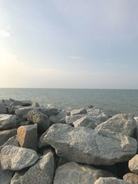 Rocks on sea shore against sky