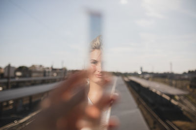 Close-up of woman reflecting on prism against sky