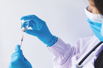 Low angle view of people holding hands against white background