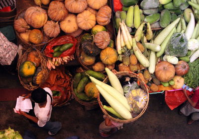 High angle view man walking by vegetables for sale in market