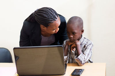 Side view of woman using laptop at home