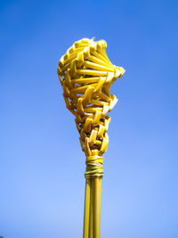 Low angle view of yellow bell against blue sky