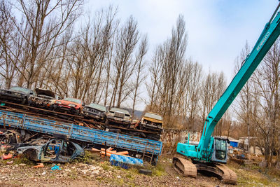 Low angle view of crane against trees