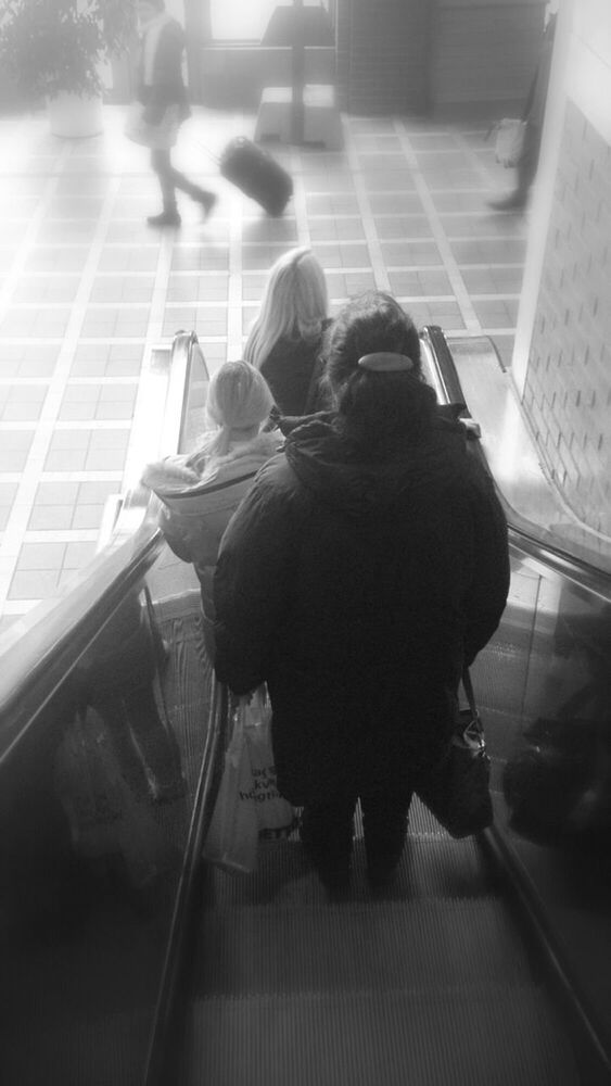 LOW ANGLE VIEW OF PEOPLE ON ESCALATOR