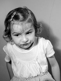 Cute baby girl against wall