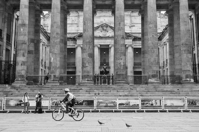 Man riding bicycle in front of building
