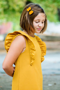 Girl in yellow dress standing on road