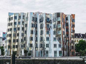 Low angle view of buildings against cloudy sky