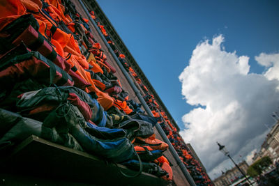 Tilt image of life jackets against cloudy sky in city