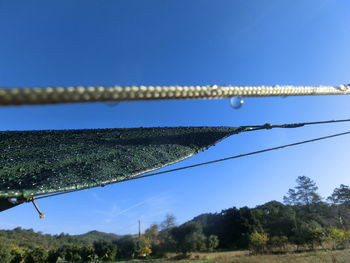 Low angle view of ropes against blue sky