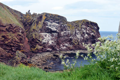 Rock formations by sea against sky