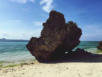 Rock on beach against sea