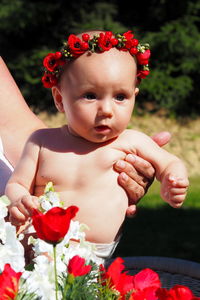 Portrait of cute baby girl with red flowers