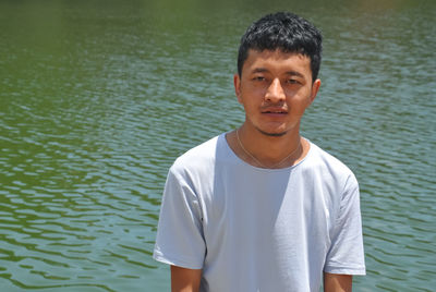 A ladakhi young guy looking at camera and standing beside of lake with copy space 