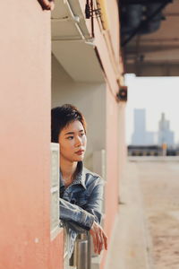 Thoughtful young woman looking away in city