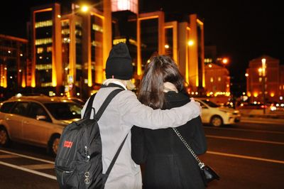 Rear view of woman on city street at night