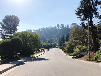 Road amidst trees against clear sky