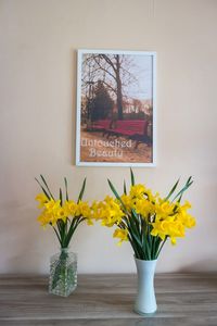 Yellow flowers in vase on window sill