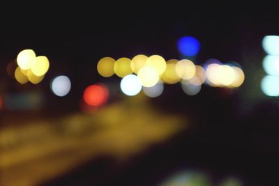Defocused lights against sky at night