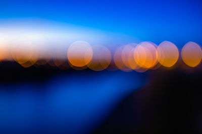 Defocused image of lights against sky at night