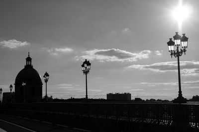 Silhouette of street light and city against sky