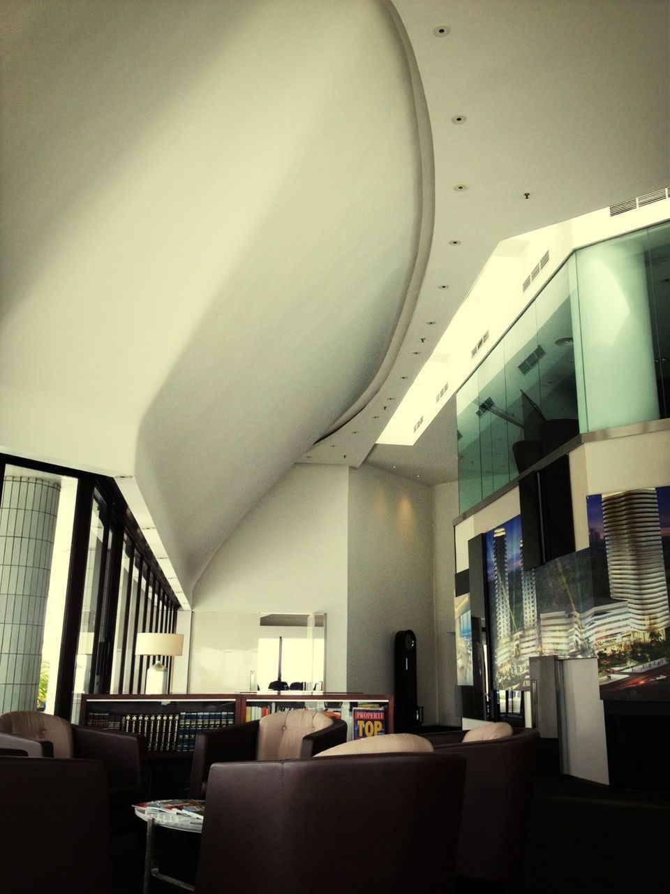 indoors, architecture, built structure, ceiling, empty, interior, absence, window, illuminated, lighting equipment, chair, building, corridor, in a row, modern, no people, architectural column, low angle view, sunlight, architectural feature