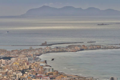 High angle view of townscape by sea against sky